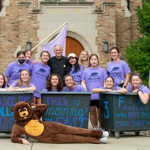 President Rev. John I. Jenkins, C.S.C. poses with Flaherty Hall residents, one of whom is dressed in a bear costume, who helped incoming first year students with move in 2022