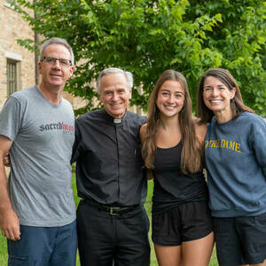 President Rev. John I. Jenkins, C.S.C. poses for a photo with an incoming first year student and her parents at Flaherty Hall on move in 2022