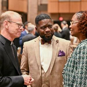 Rev. Robert A. Dowd, C.S.C., talks with two community leaders