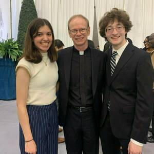 Rev. Robert A.Dowd, C.S.C., celebrates with students during Junior Parents Weekend