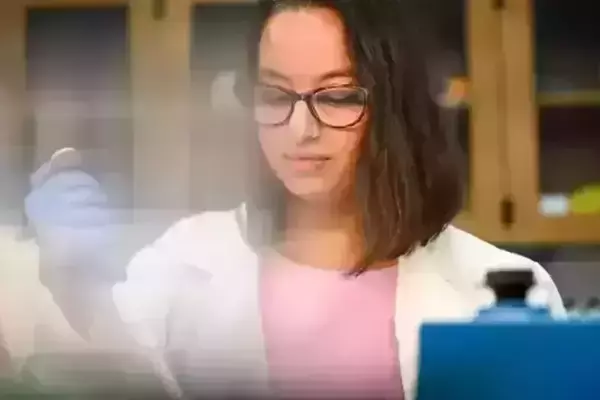 A girl wearing glasses takes a sample in a science lab