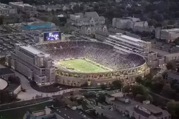 A aerial view of Notre Dame stadium at night, show the campus crossroads additions to the staidum.