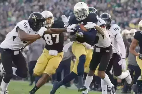 Running back Cierre Wood runs with the ball during a football game.